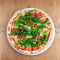 Parma Ham Pizza Topped With Fresh Rocket And Parmesan Shavings